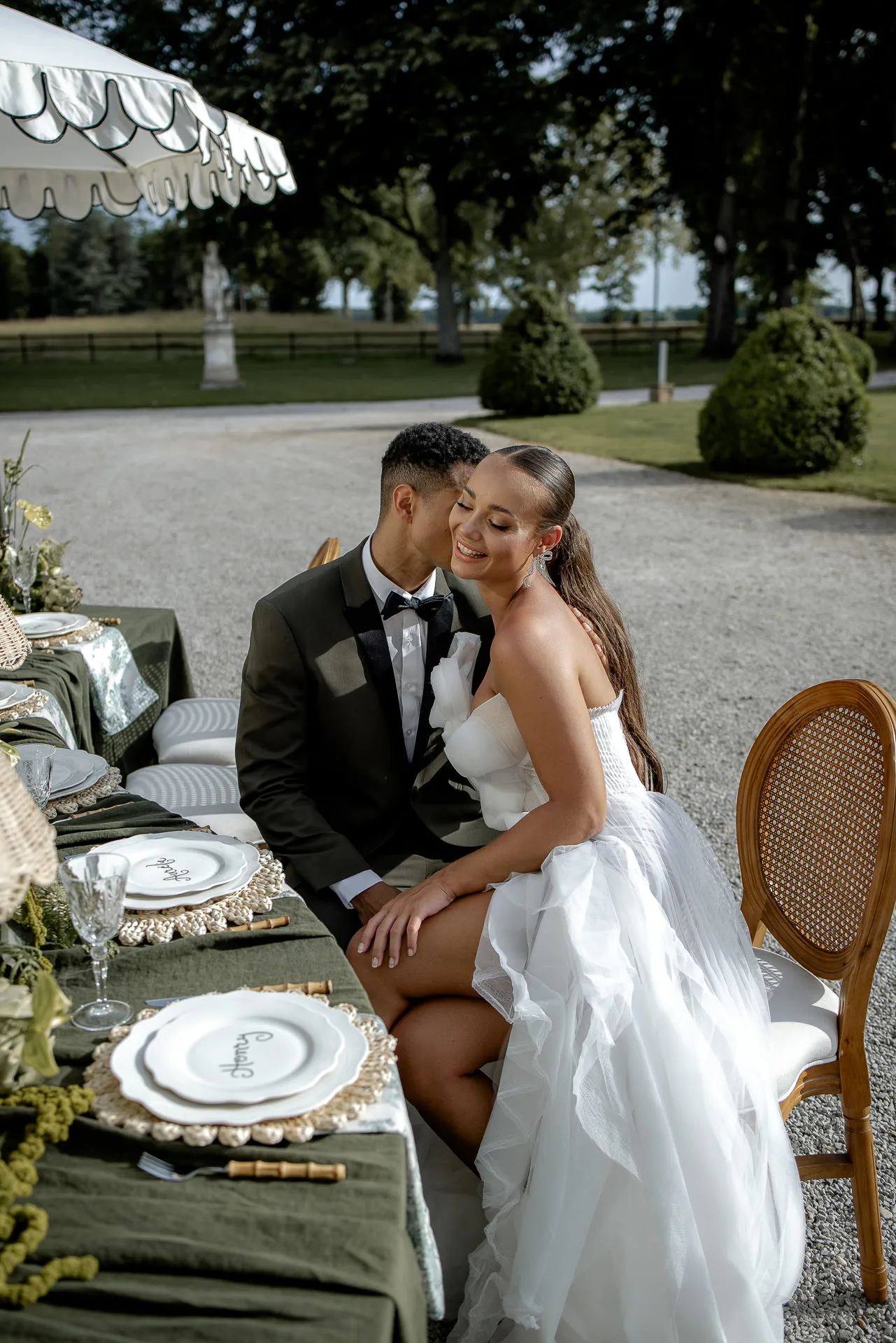 Intimes Brautpaar-Portrait am elegant gedeckten Hochzeitstisch mit grünen Tischdecken am Chateau de Varennes